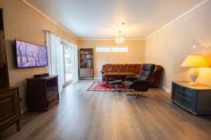 a living room with a couch and a tv at Spacious Apartment - City Center in Stryn