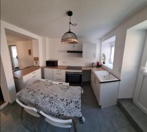 a kitchen with a table and a small kitchen with a table and chairs at Le Stein in Steinbach