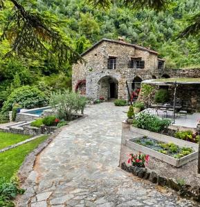 an external view of a stone house with a garden at Old Mill in Pigna