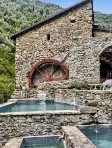 a stone building with a water fountain in front of it at Old Mill in Pigna