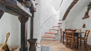 a dining room with a table and chairs and stairs at Old Mill in Pigna