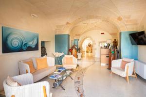 a living room with white furniture and an archway at Corte Di Nettuno - CDSHotels in Otranto