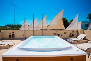 a hot tub on the roof of a building with sails at Corte Di Nettuno - CDSHotels in Otranto