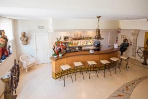 a room with a bar with chairs and a counter at Corte Di Nettuno - CDSHotels in Otranto