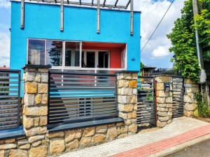 a blue house with a stone wall at Ubytko 151 Broumov in Broumov