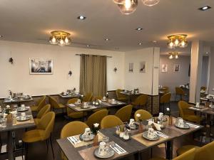 a restaurant with wooden tables and yellow chairs at Best Western Empire Elysees in Paris