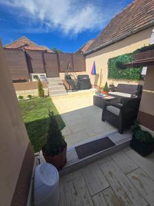 a patio with a couch and a table and chairs at Casa Izabella in Tîrnăveni