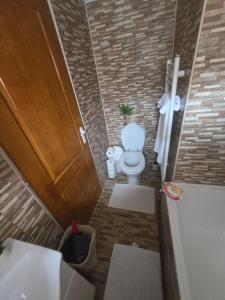 a bathroom with a toilet and a sink and a tub at Casa Izabella in Tîrnăveni
