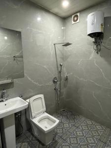 a bathroom with a white toilet and a sink at Gorumara Jungle Resort in Chālsa