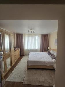 a bedroom with a bed and a dresser and a window at Casa Izabella in Tîrnăveni