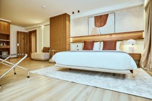 a bedroom with a large white bed and a rug at Hôtel Ivotel Abidjan in Abidjan