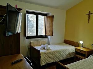 a small bedroom with two beds and a window at Casa per Ferie Ulivo d'Assisi in Assisi