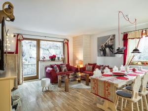 a living room with a table and a couch at TatryTop Domek Miód Malina in Zakopane