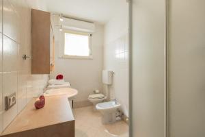 a white bathroom with a toilet and a sink at Angelic Darsena Apartment in Ravenna +23 photos