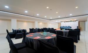 a banquet hall with black tables and chairs at HHW Hotel- Agra in Agra