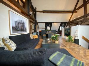 a living room with a black couch and a table at Château de Clemency in Clemency