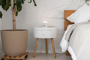 a bed with a white night stand next to a bed at Wintergarten Wohnung mit Feldblick nahe Legoland in Jettingen-Scheppach
