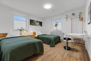 a bedroom with two beds and a desk and a table at Wintergarten Wohnung mit Feldblick nahe Legoland in Jettingen-Scheppach
