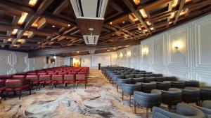 an empty auditorium with red chairs and a stage at Sarovar Premiere Srinagar in Srinagar