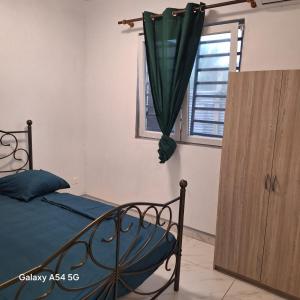 a bedroom with a bed and a window at Fayalobi in Saint-Laurent du Maroni