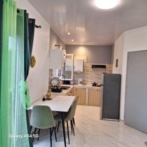 a kitchen with a table and chairs and a refrigerator at Fayalobi in Saint-Laurent du Maroni