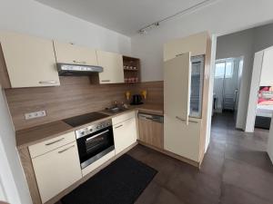 a kitchen with white cabinets and a stove top oven at Ferienwohnung Sophia in Bad Gleichenberg