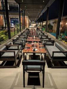 a long row of tables and chairs in a restaurant at Prakruthi Retreat Belagavi in Belgaum