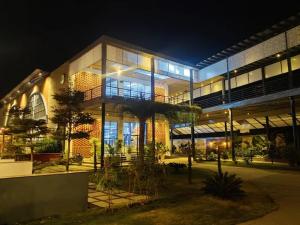 a large building with a lot of windows at night at Prakruthi Retreat Belagavi in Belgaum