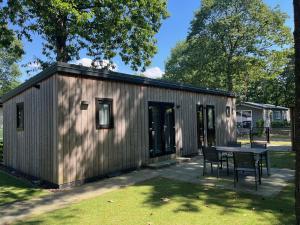 a small shed with a table in a yard at Bospark Wolfsven - 1511 in Mierlo