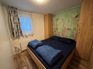 a bedroom with a bed with a painting on the wall at Bospark Wolfsven - 1511 in Mierlo
