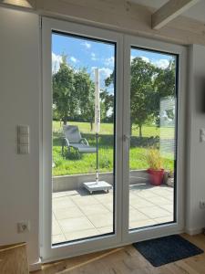 an open sliding glass door with a chair outside at Tinyhaus Ferien in Eggolsheim +44 photos
