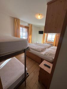 a bedroom with three bunk beds and a window at Chalet Del Sole per gruppi in Livigno +216 photos