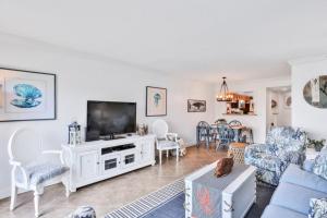 a living room with a television on a white cabinet at Summerhouse 147 condo in St. Augustine
