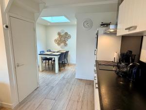 a kitchen with a table and a dining room at SummerTime Bergen aan Zee in Bergen aan Zee
