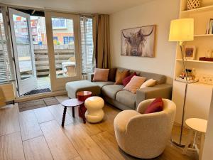 a living room with a couch and two chairs at SummerTime Bergen aan Zee in Bergen aan Zee