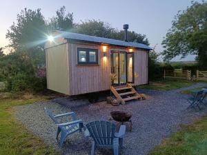 a tiny house with two chairs and a table at Old Quay Escape in Tenby