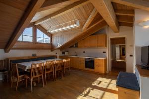 a kitchen with a table and chairs in a room at Chalet Del Sole per gruppi in Livigno