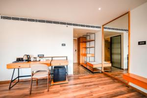 a kitchen with a table and a mirror at Nestlay Suites by TC One in Kozhikode