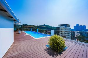 a deck with a swimming pool on top of a building at Nestlay Suites by TC One in Kozhikode
