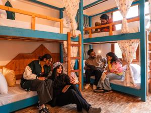 a group of people sitting in bunk beds at Moustache Manali in Manāli