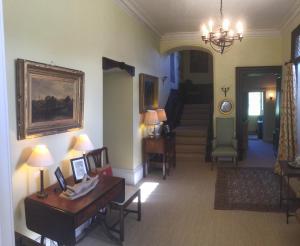 安斯蒂的住宿－Higher Melcombe Manor，一间带桌椅和楼梯的客厅