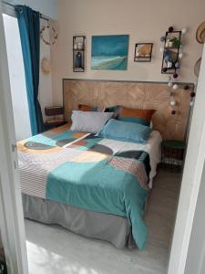 a bedroom with a large bed with blue pillows at les vagues a Bénodet in Bénodet