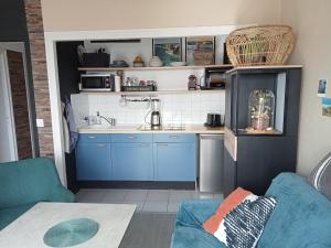 a small kitchen with blue cabinets and a sink at les vagues a Bénodet in Bénodet