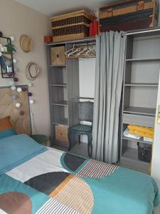a bedroom with a bed and a chair and shelves at les vagues a Bénodet in Bénodet