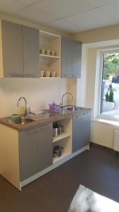 a kitchen with a sink and two sinks and a window at Bridge Hotel in Rīga