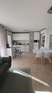 a living room with a table and chairs and a kitchen at Bel appartement en bord de mer avec piscine lagon et jardin, en résidence sécurisée in Antibes