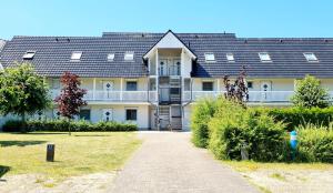 a large building with a walkway in front of it at Hafenidyll 46 - exklusiv am Yachthafen mit zwei Bädern - traumhafte Sonnenuntergänge inklusive in Karlshagen