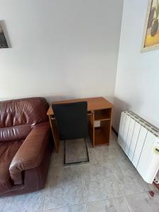 a couch and a desk with a chair next to a table at Alquiler Vacacional en Ribeira in Ribeira