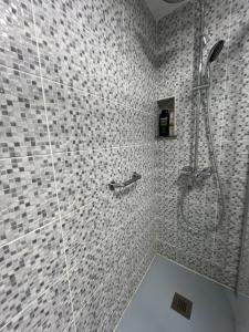a bathroom with a shower with white tiles at Alquiler Vacacional en Ribeira in Ribeira +9 photos