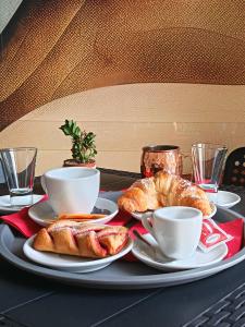 a table with a plate of croissants and coffee cups at B&B A' Kiazza in Buompietro